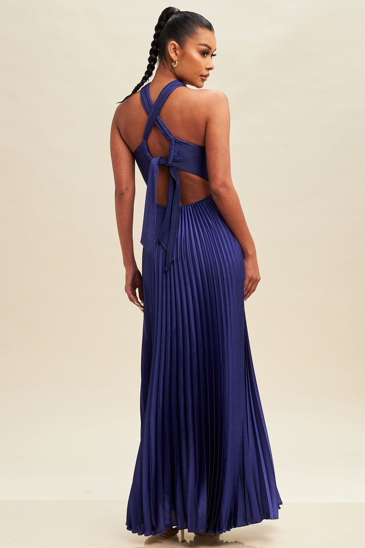 A model wearing a royal blue maxi dress with crisscross pleats and a halter neck.