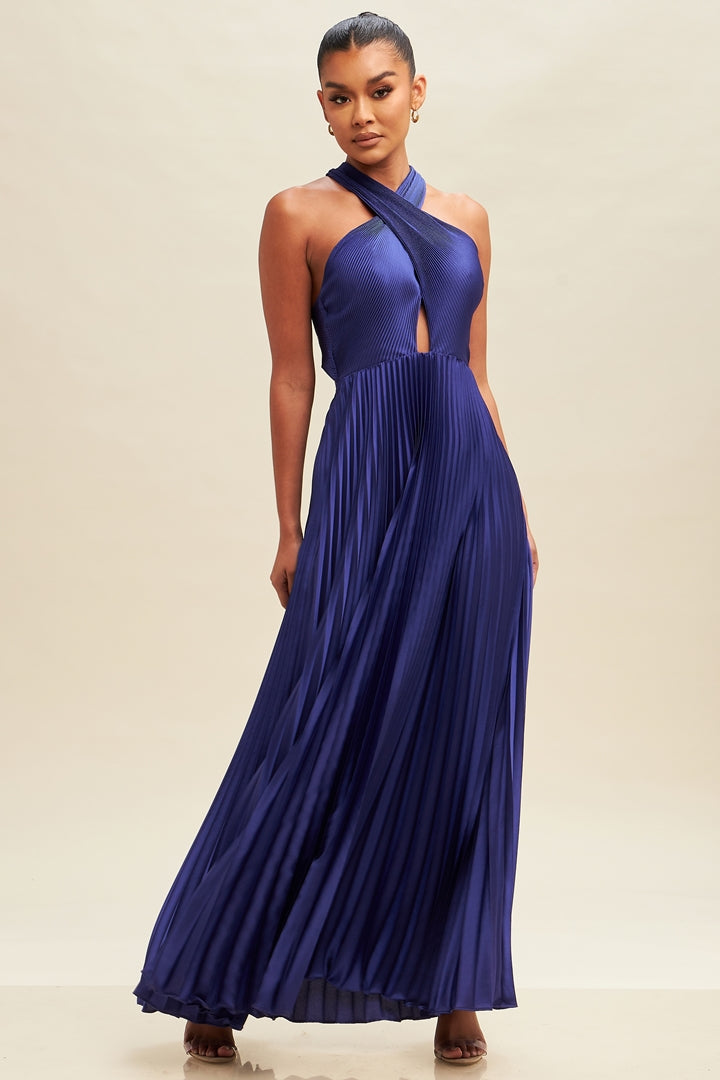 A model wearing a royal blue maxi dress with crisscross pleats and a halter neck.