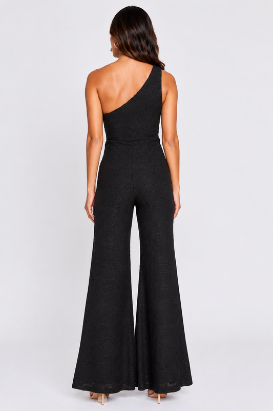 Black one-shoulder jumpsuit worn by a model on a white background