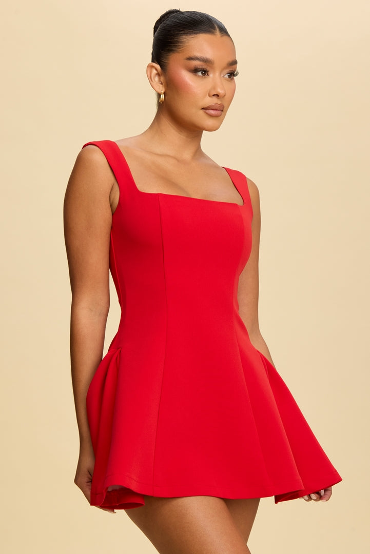 Woman wearing a red dress against a beige background