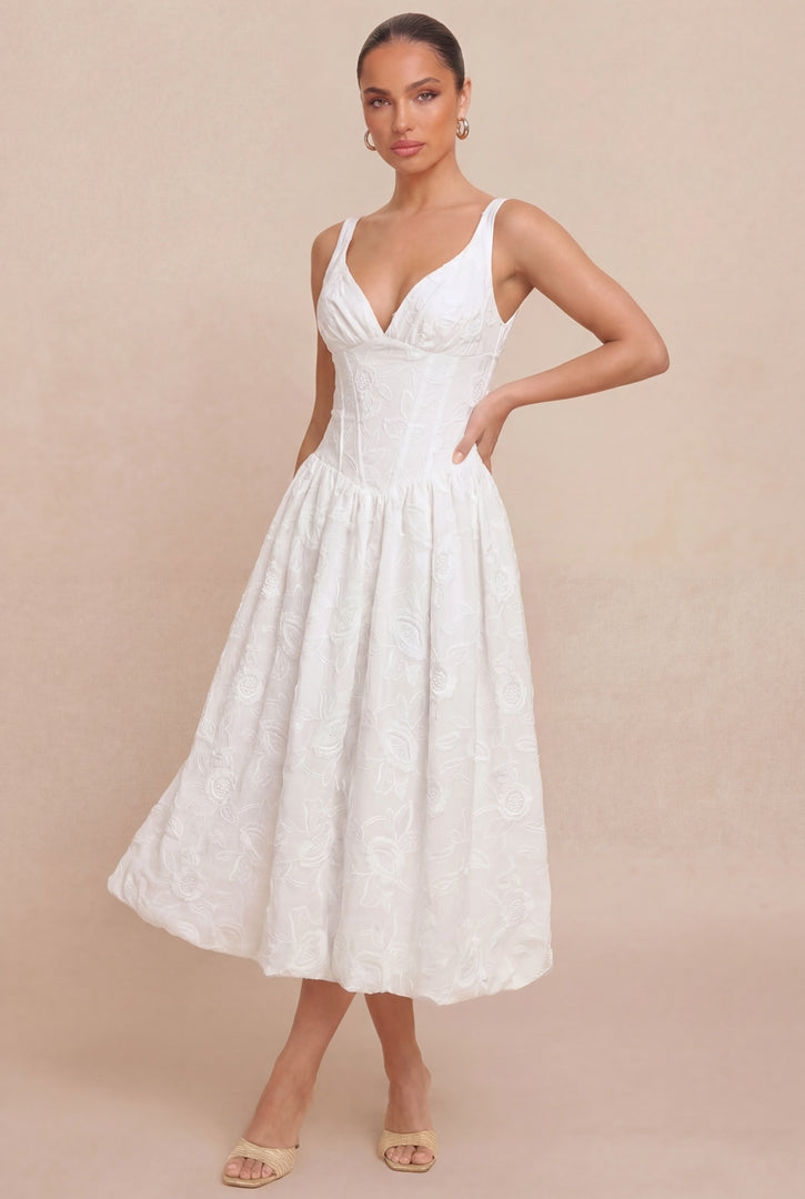 Woman wearing a white lace dress against a beige background