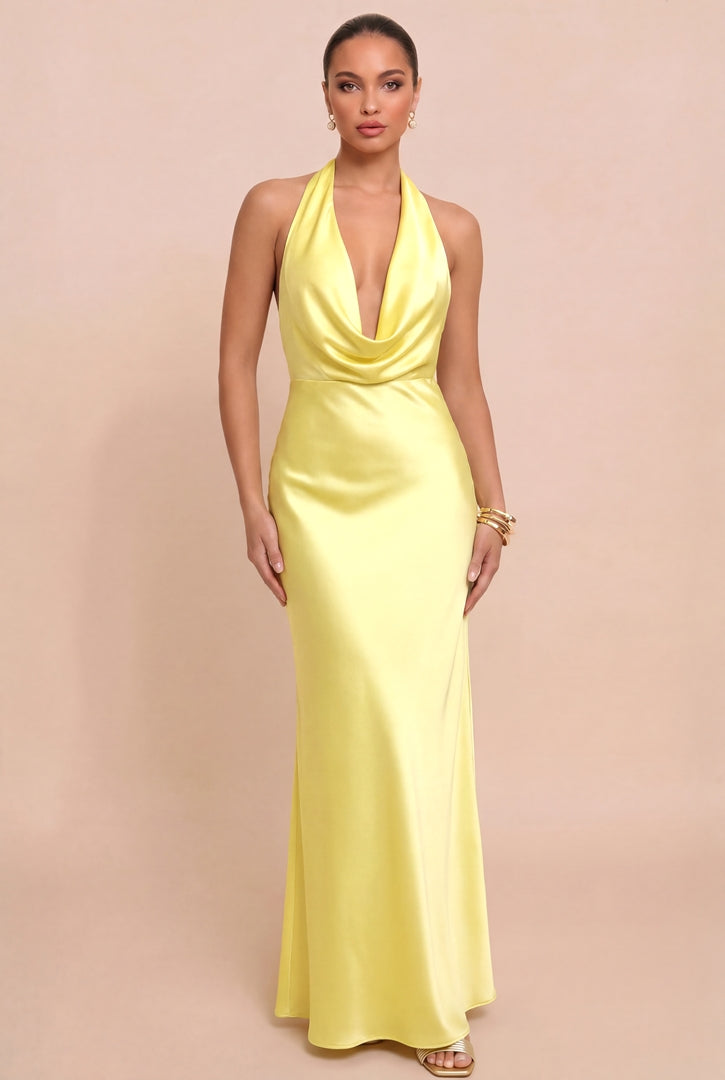 Woman wearing a yellow halter neck gown against a beige background